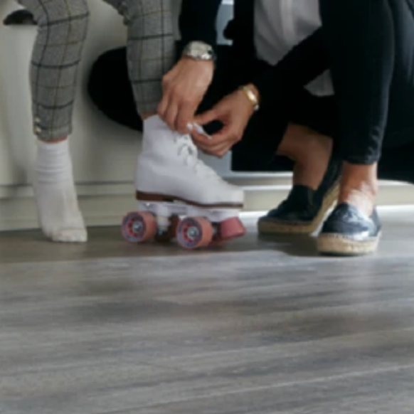 Parent putting roller skates on a child in a home with durable flooring